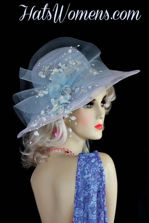 Ladies Pastel Baby Blue Designer Kentucky Derby Hat. This Fashion Hat Is Embellished With A Baby Blue Sheer Crin Netting Bow, Accented With Baby Sky Blue Silk Millinery Flowers, Including Rose Buds. Sweeping White Pearls Give This Formal Hat Such A Feminine Touch. A Lovely White Trim Wraps Around The Crown Of This Elegant Hat. This dress hat is suited for Winter, Spring, Summer And Fall.