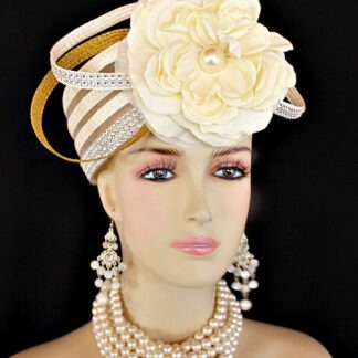 Ladies 1920's Style Flapper Art Deco Era Ivory Metallic Gold Pillbox Church Wedding Bridal Cocktail Hat. This Formal Straw Braid Hat Is Embellished With A Large Ivory Double Loop Bow Enhanced With Clear Acrylic Rhinestones, Accented With Two Metallic Gold Double Looped Bows. A Large Ivory Millinery Silk Flower With A Large Pearl Center Is Placed In The Center Of This Beautiful Custom Made Bow.  Four Rows Of Rhinestones Encircle The Crown Of This Fashion Wedding Headpiece. This Designer Hat Is Suited For A Bride To Be On Her Wedding Day Or For A Wedding Guest. A Beautiful Dress Hat To Wear To Church, Formal, Horse Races, The Kentucky Derby And Formals. This Dress Couture Hat Is Custom Made And Designed By Dress Hats For Women, https://www.dresshatsforwomen.com