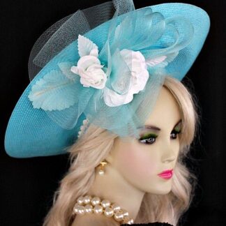 Turquoise Blue Haute Couture Avant Garde Designer Fashion Hat With A Lift Up Brim For Women. This Designer Dress Hat Is Trimmed With A Large Turquoise Blue Crin Rosette Bow, Adorned With White Silk Millinery Roses And Aqua Millinery Silk Leaves. The Same Roses And Leaves Are Placed On The Back Of This Wide Brim Hat. A White Intricate Trim Wraps Around The Crown Of This Hat.
