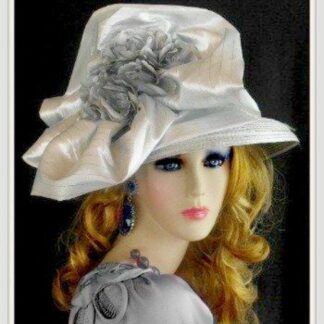 Silver grey ladies designer Church hat. This impressive fashionable hat is adorned with a large bow with pin stripes. This lovely hat is embellished with silver metallic, grey flowers.  In the center of these flowers, are satin grey flowers, with white pearls. This hat, represents timeless elegance, at its finest. 