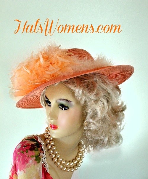 Ladies Peach Or Pastel Orange Designer Wide Brim Wedding Special Occasion Formal Hat. This Peach Formal Custom Made Church Hat, Is Trimmed With Peach Chandelle Feathers. Delicate Ivory Colored Fur Like Feathers Incircle The Crown Of This Hat, Giving This Hat Such Elegance.